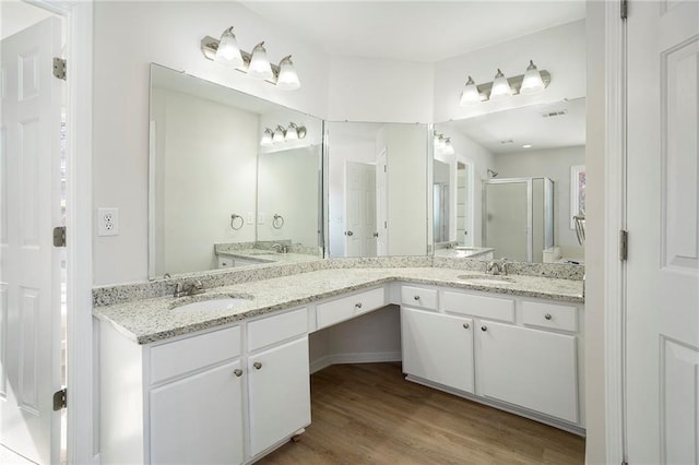 10950 Glenhurst, Duluth, GA 30097 - bathroom featuring a shower stall, double vanity, and wood finished floors