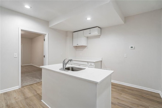 10950 Glenhurst, Duluth, GA 30097 - kitchen featuring light wood-style floors, white cabinetry, light countertops, a center island with sink, and recessed lighting
