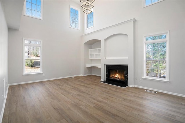 10950 Glenhurst, Duluth, GA 30097 - unfurnished living room with a high ceiling, wood finished floors, a fireplace with flush hearth, and built in features