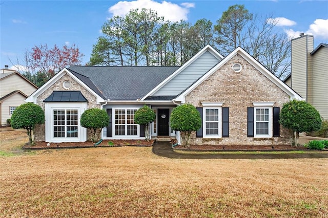 view of front of home featuring a front lawn, brick siding, and a shingled roof