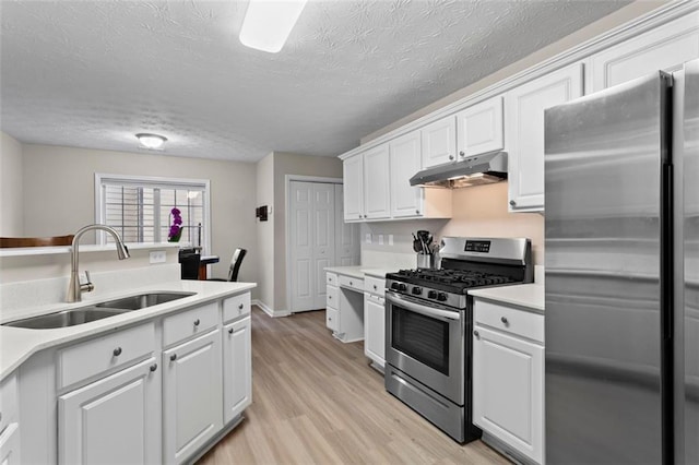 kitchen featuring a sink, under cabinet range hood, white cabinetry, stainless steel appliances, and light countertops