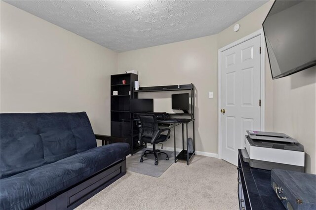 carpeted home office featuring baseboards and a textured ceiling