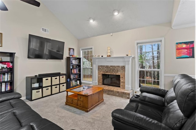 living area featuring visible vents, carpet floors, baseboards, a fireplace, and vaulted ceiling