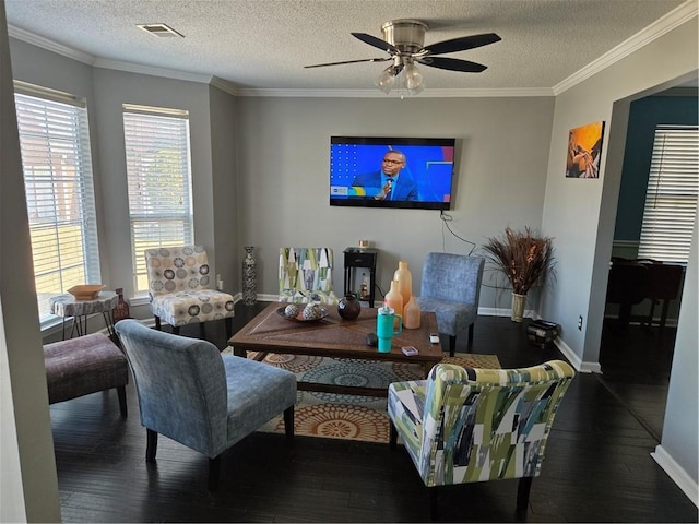 living area featuring visible vents, a ceiling fan, wood finished floors, crown molding, and baseboards