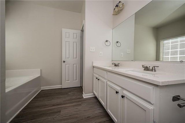 bathroom featuring hardwood / wood-style flooring, vanity, and a bathtub