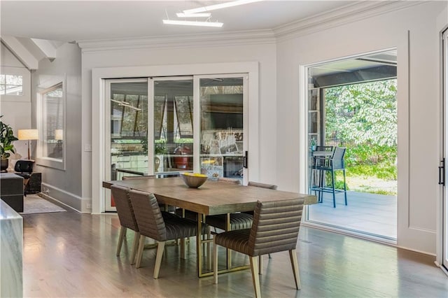 dining area featuring crown molding, baseboards, and wood finished floors