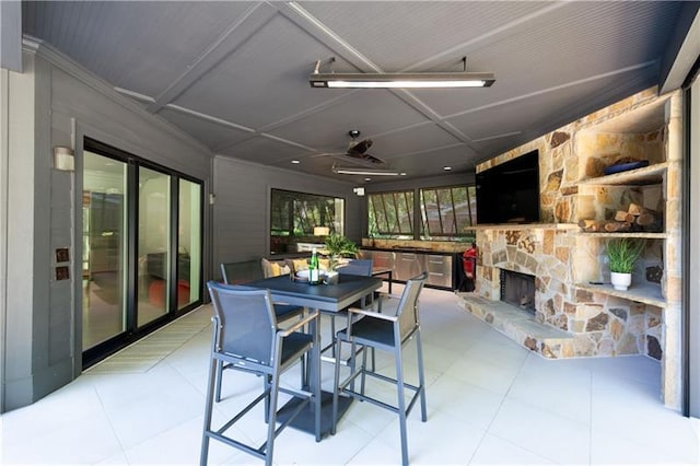 dining space featuring an outdoor stone fireplace and light tile patterned flooring