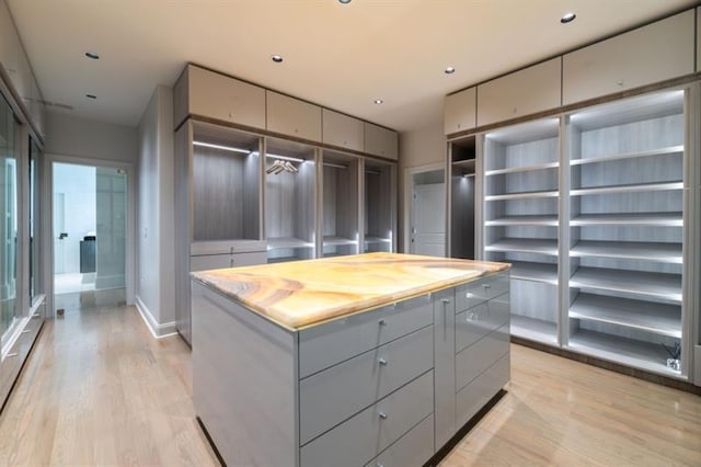 walk in closet with light wood-style floors