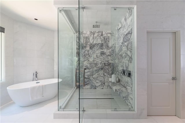 bathroom featuring tile walls, a soaking tub, and a shower stall