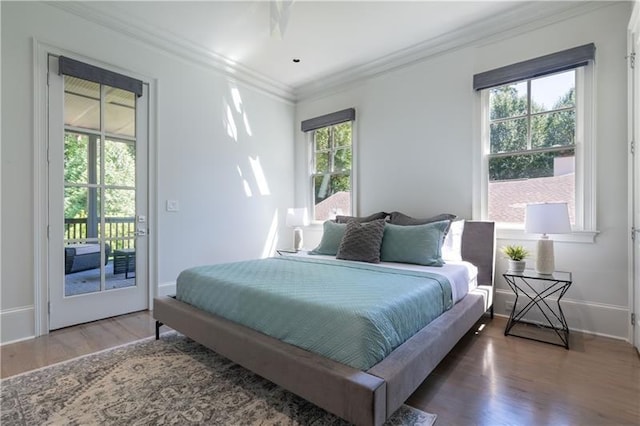 bedroom featuring access to exterior, crown molding, baseboards, and wood finished floors