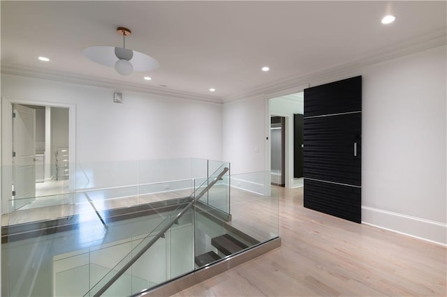 hall featuring light wood-type flooring, crown molding, baseboards, and recessed lighting