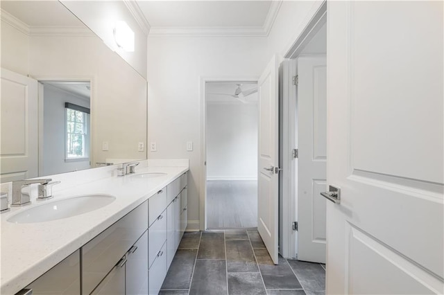 bathroom featuring double vanity, crown molding, baseboards, and a sink