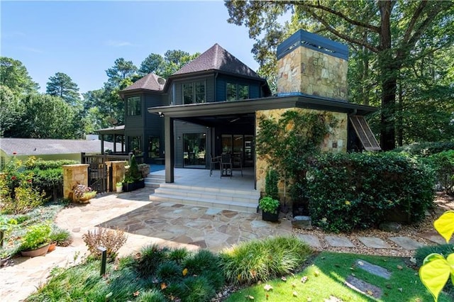 rear view of house with a patio and stone siding