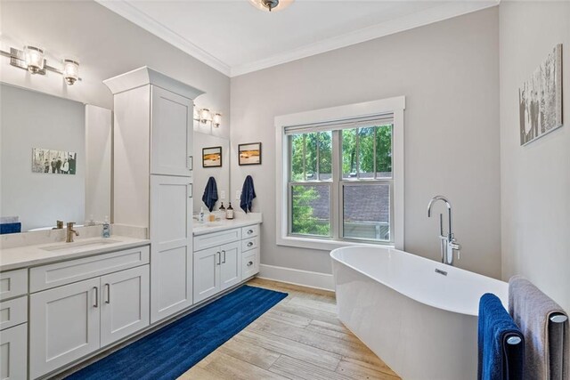 629 2nd Ave, Decatur, GA 30030 - bathroom featuring vanity, a freestanding bath, wood finished floors, ornamental molding, and baseboards