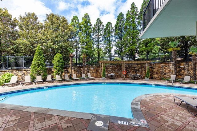 community pool with fence and a patio