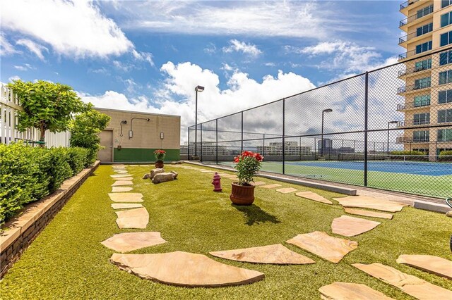 view of tennis court featuring fence