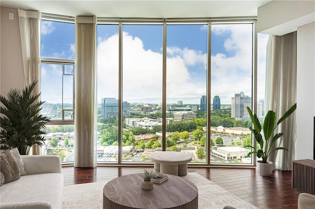 living room with floor to ceiling windows, a city view, and hardwood / wood-style flooring
