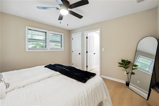 bedroom featuring light hardwood / wood-style flooring, multiple windows, and ceiling fan