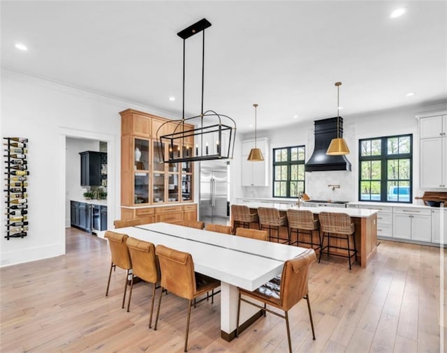dining space featuring recessed lighting, light wood-style floors, crown molding, and baseboards