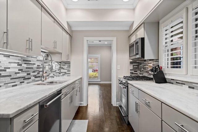 kitchen featuring stainless steel appliances, a sink, dark wood-style flooring, ornamental molding, and tasteful backsplash