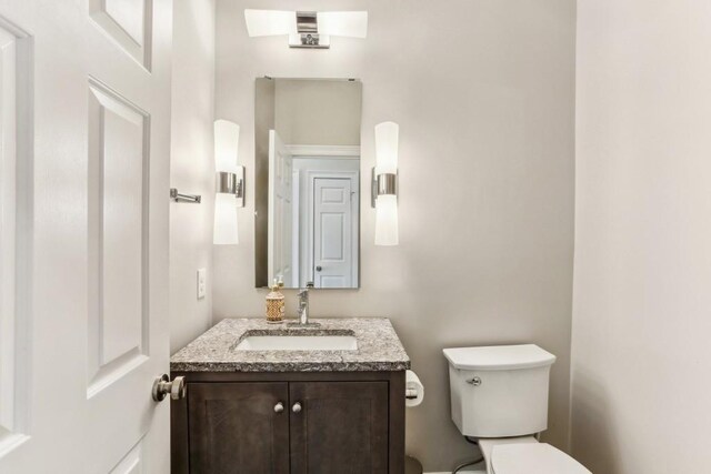 half bathroom featuring toilet and vanity