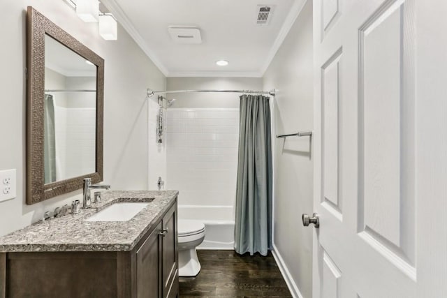 full bathroom featuring ornamental molding, toilet, wood finished floors, vanity, and shower / tub combo