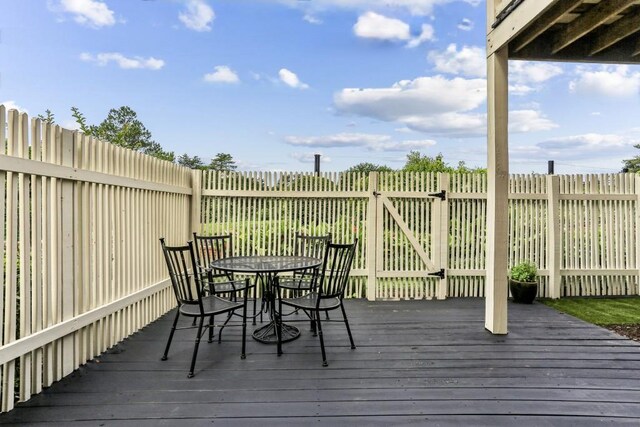 wooden terrace featuring outdoor dining space and fence