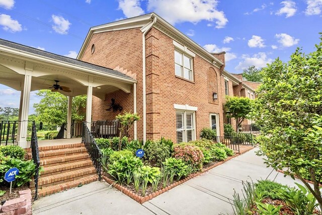 rear view of property with a chimney and brick siding