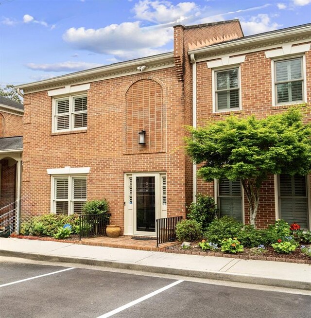 property entrance featuring a ceiling fan, a porch, and brick siding