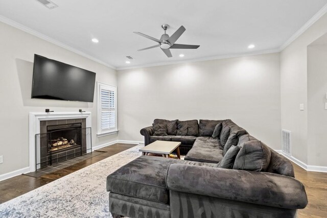 living area featuring dark wood-type flooring, a ceiling fan, recessed lighting, baseboards, and ornamental molding