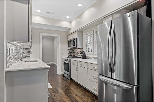 kitchen featuring stainless steel appliances, a sink, ornamental molding, backsplash, and recessed lighting