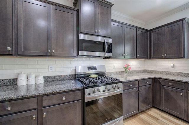 544 Pine Way, Dallas, GA 30157 - kitchen with stainless steel appliances, dark brown cabinets, dark stone countertops, ornamental molding, and light wood finished floors