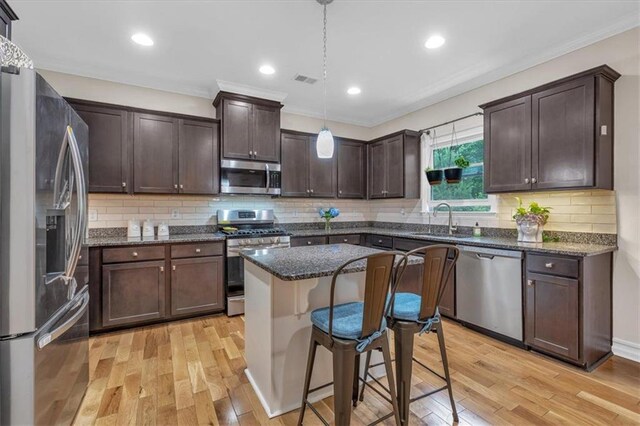 544 Pine Way, Dallas, GA 30157 - kitchen with appliances with stainless steel finishes, a sink, light wood-type flooring, dark brown cabinets, and ornamental molding