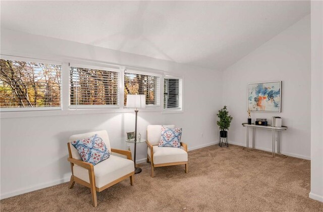 sitting room featuring light carpet, plenty of natural light, and lofted ceiling