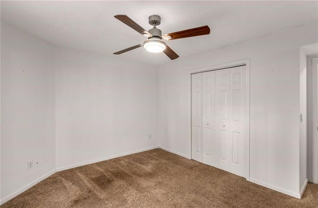 unfurnished bedroom with carpet flooring, ceiling fan, and a closet