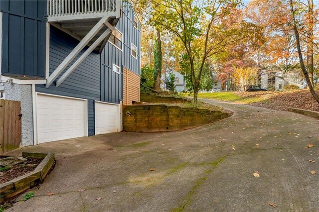 view of property exterior featuring a balcony and a garage