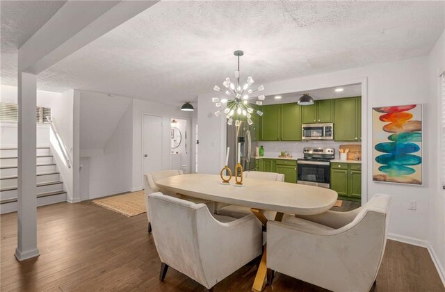 dining area featuring a chandelier, a textured ceiling, and dark wood-type flooring