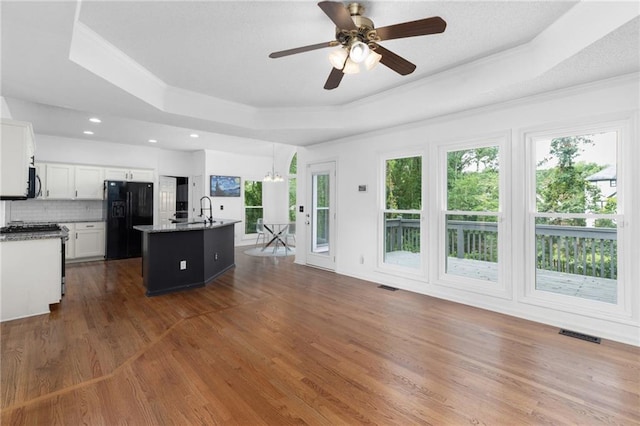 1612 Branch Creek Cv, Lawrenceville, GA 30043 - kitchen with freestanding refrigerator, a raised ceiling, crown molding, a kitchen island with sink, and ceiling fan