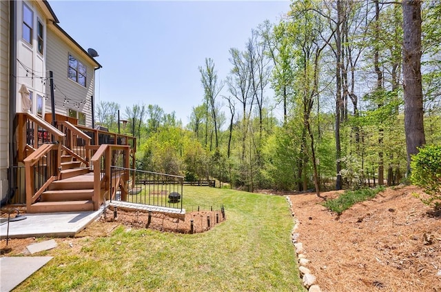 view of yard with a patio, a deck, and stairs