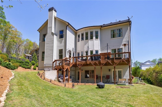 back of house featuring a patio, a wooden deck, a yard, and a chimney