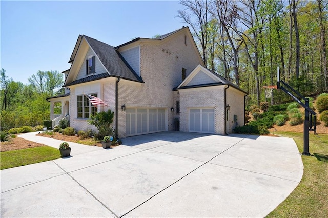 view of side of home featuring concrete driveway, brick siding, and an attached garage