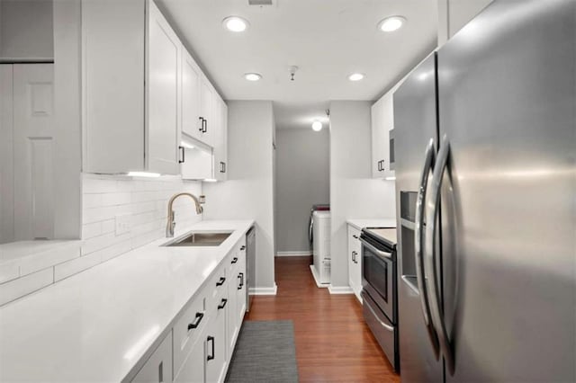 kitchen with light countertops, appliances with stainless steel finishes, a sink, and dark wood-type flooring