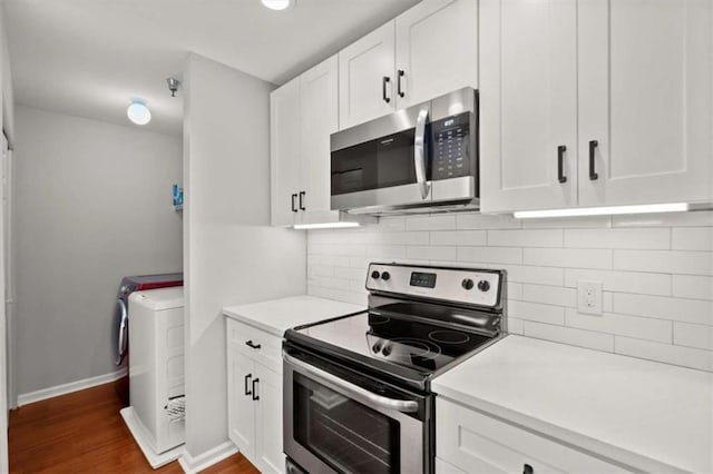 kitchen featuring washer and dryer, white cabinets, appliances with stainless steel finishes, and light countertops