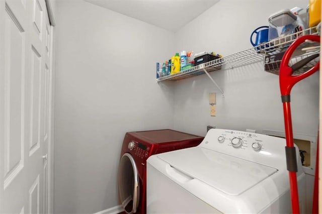 washroom featuring laundry area, baseboards, and washing machine and dryer