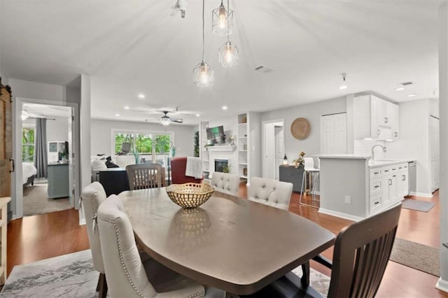 dining area featuring recessed lighting, ceiling fan, light wood-type flooring, and a fireplace