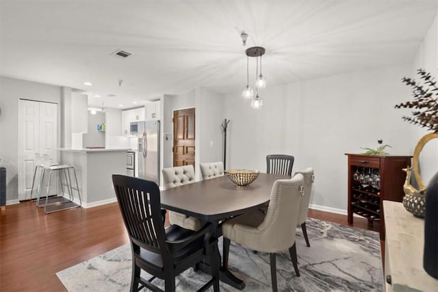 dining room featuring baseboards, dark wood-style flooring, and visible vents