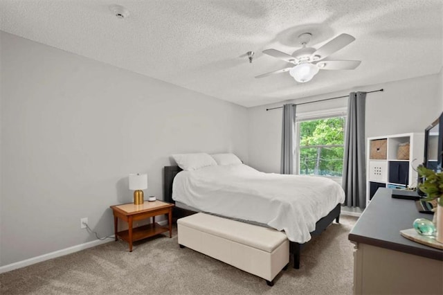 carpeted bedroom featuring baseboards, a textured ceiling, and ceiling fan