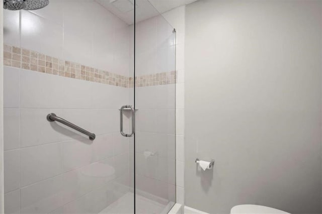 full bathroom with a stall shower and toilet