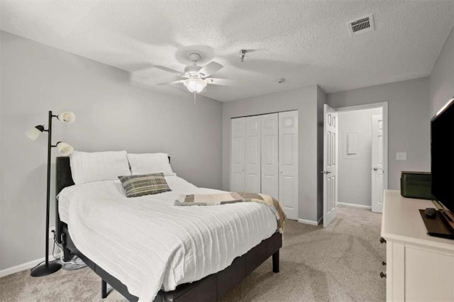 bedroom with baseboards, light carpet, a closet, and visible vents