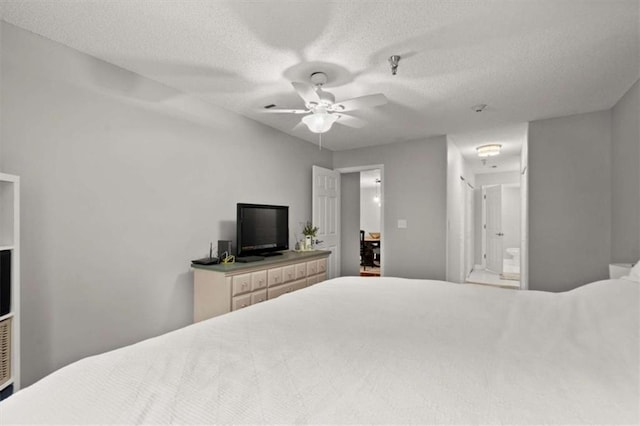 bedroom featuring ensuite bathroom, a ceiling fan, and a textured ceiling